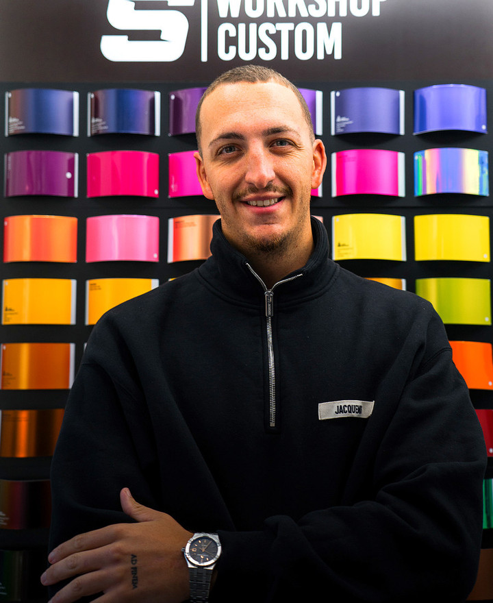 Jason Sunier, fondateur de S Workshop Custom, devant le nuancier de l'atelier