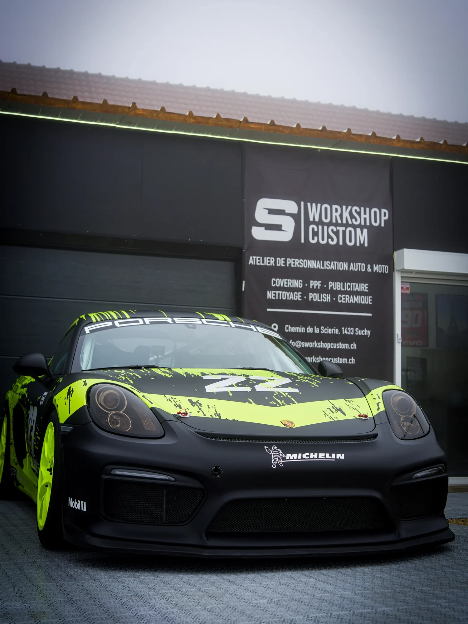 Porsche GT4 Clubsport en full covering devant l'atelier