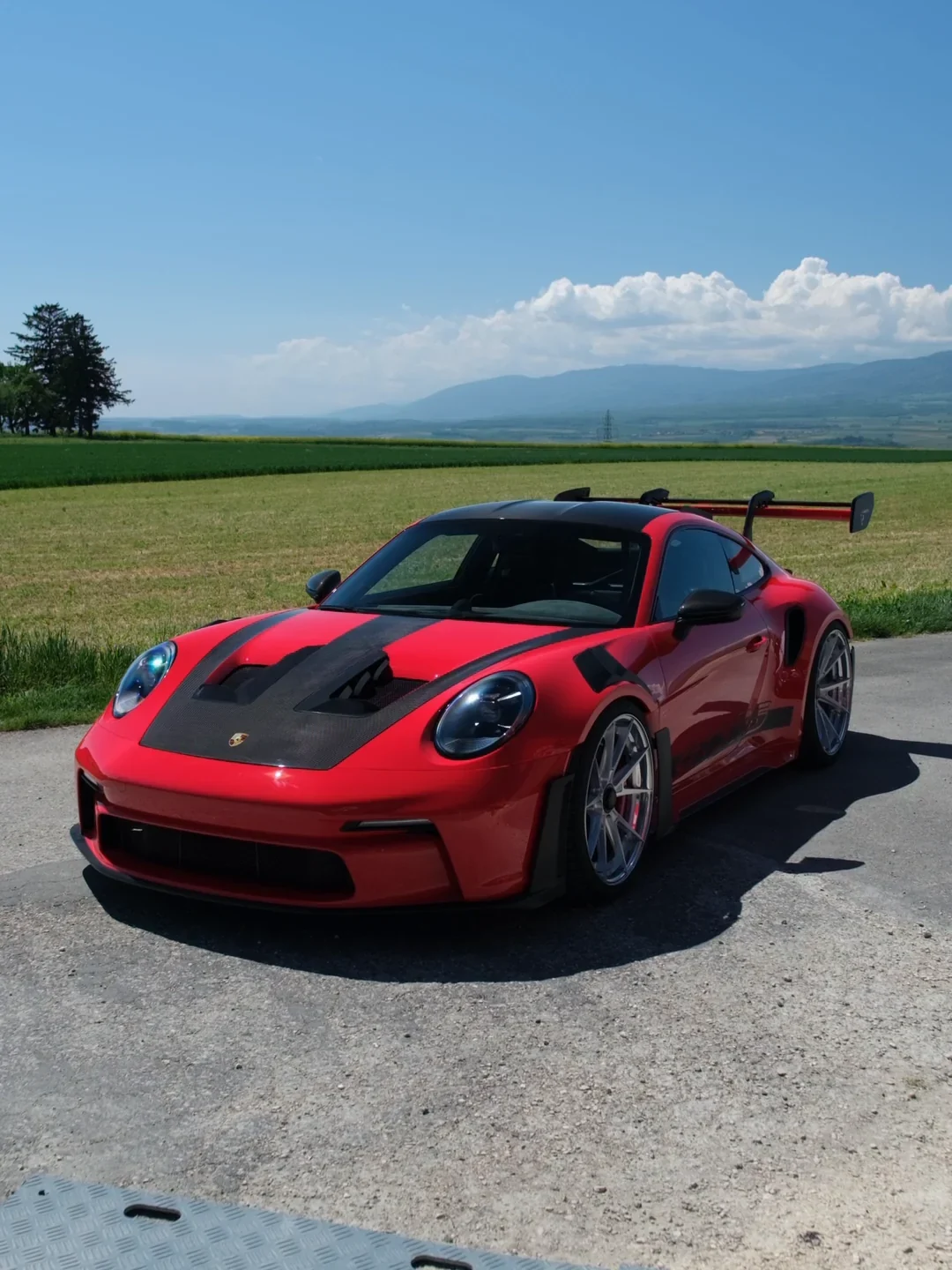 Porsche GT3 RS en full PPF couleur rouge, champs et montagnes