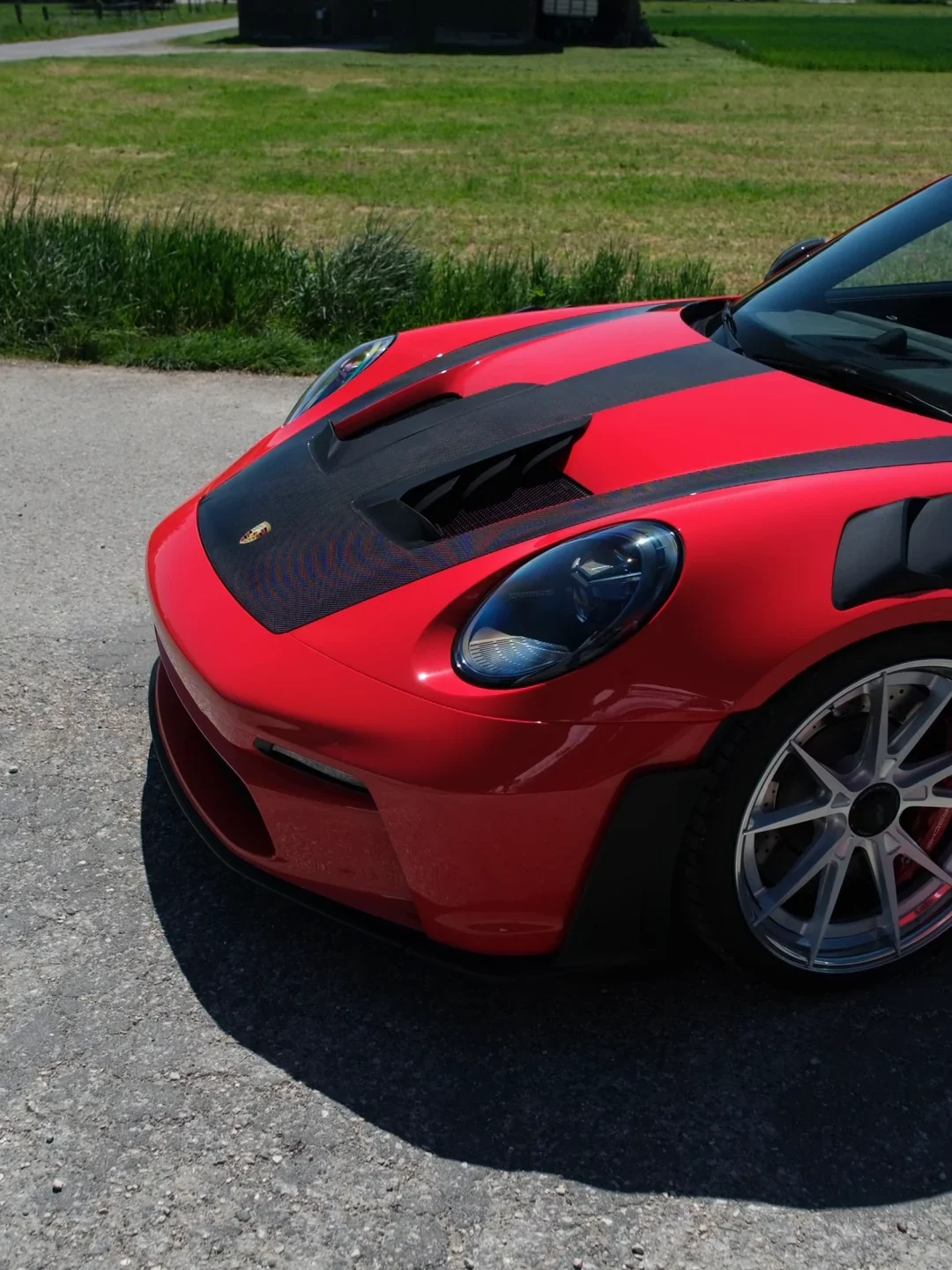 Avant d'une Porsche GT3 RS en full PPF couleur rouge, capot carbone