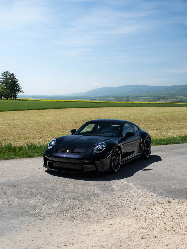 Porsche GT3 Touring noire, PPF face avant, de trois quarts avant, champs et collines