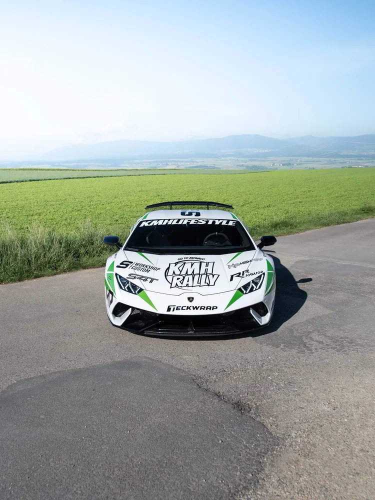 Lamborghini Huracán blanche en kit déco KMH Rally vue de face, champs et montagnes