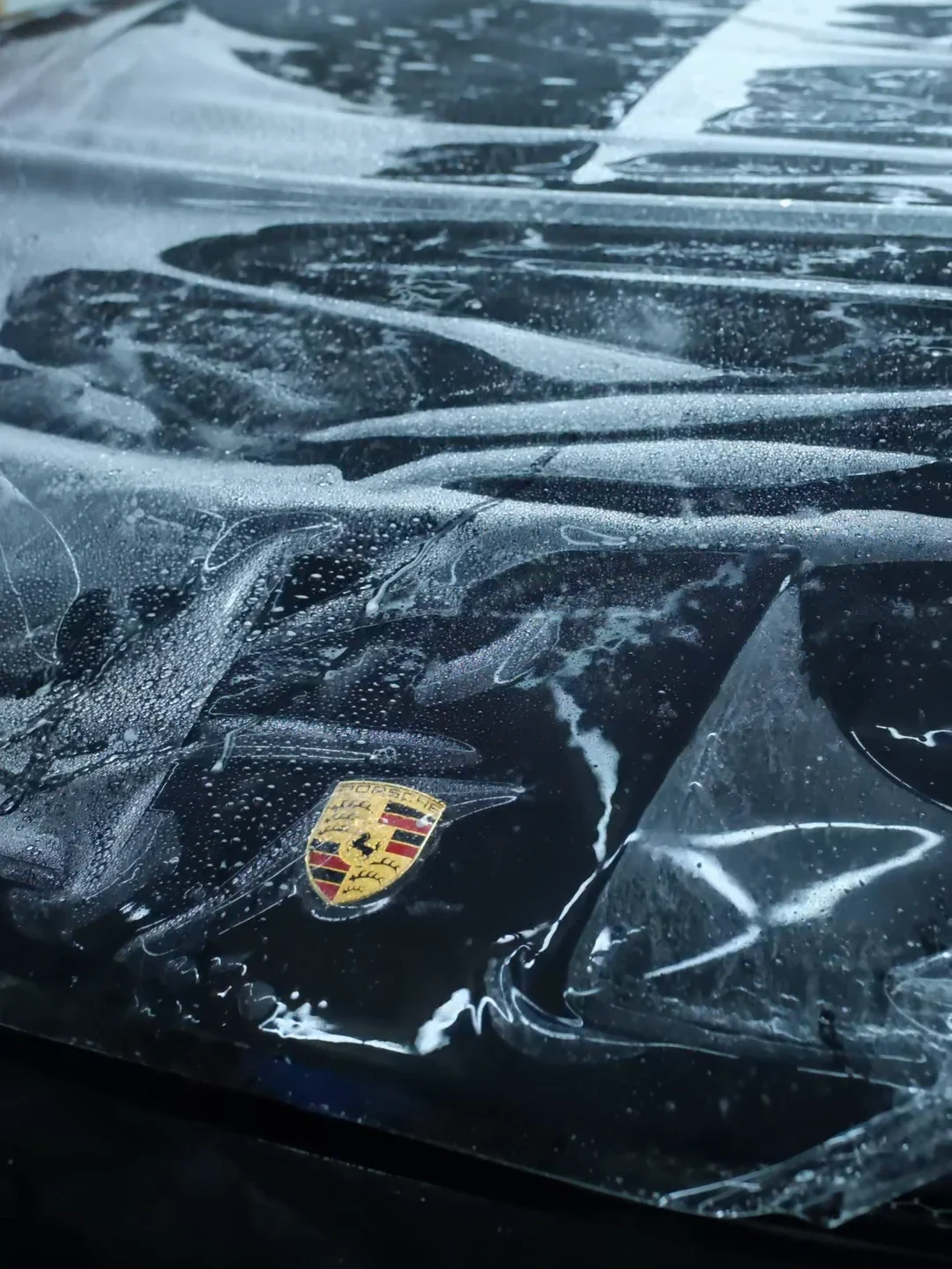 Pose de film à l'eau sur le capot d'une Porsche, à l'atelier