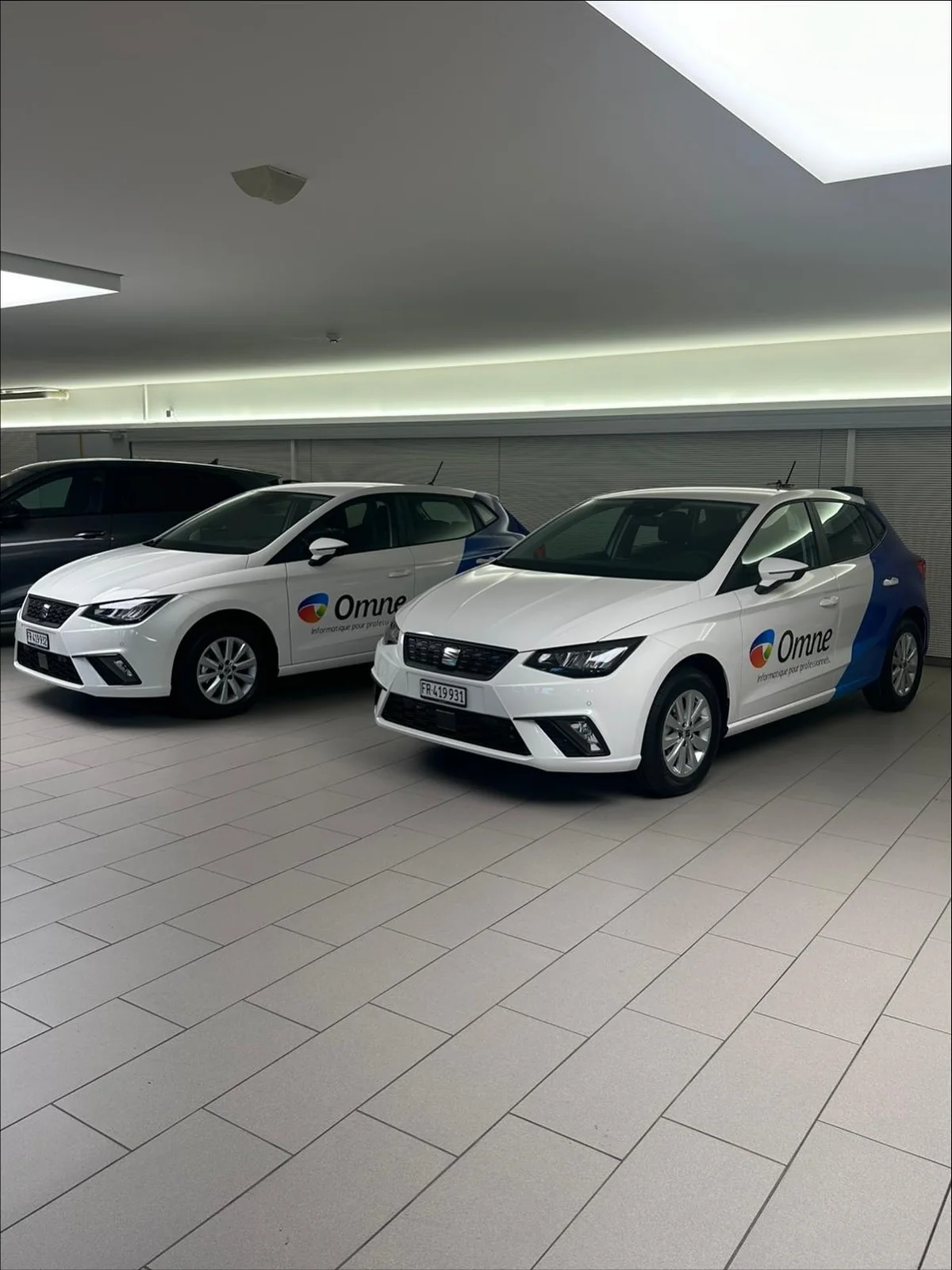Deux Seat Ibiza blanches en demi covering publicitaire, dans le showroom
